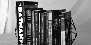 A black and white image of some books Looseleaf has worked on. Notables are Batman Black and White and leatherbound Elantris by Brandon Sanderson.